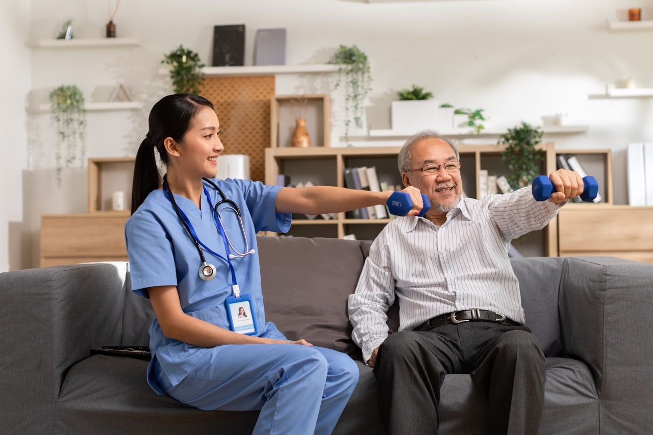 A female nurse assisting an elderly patient with exercise