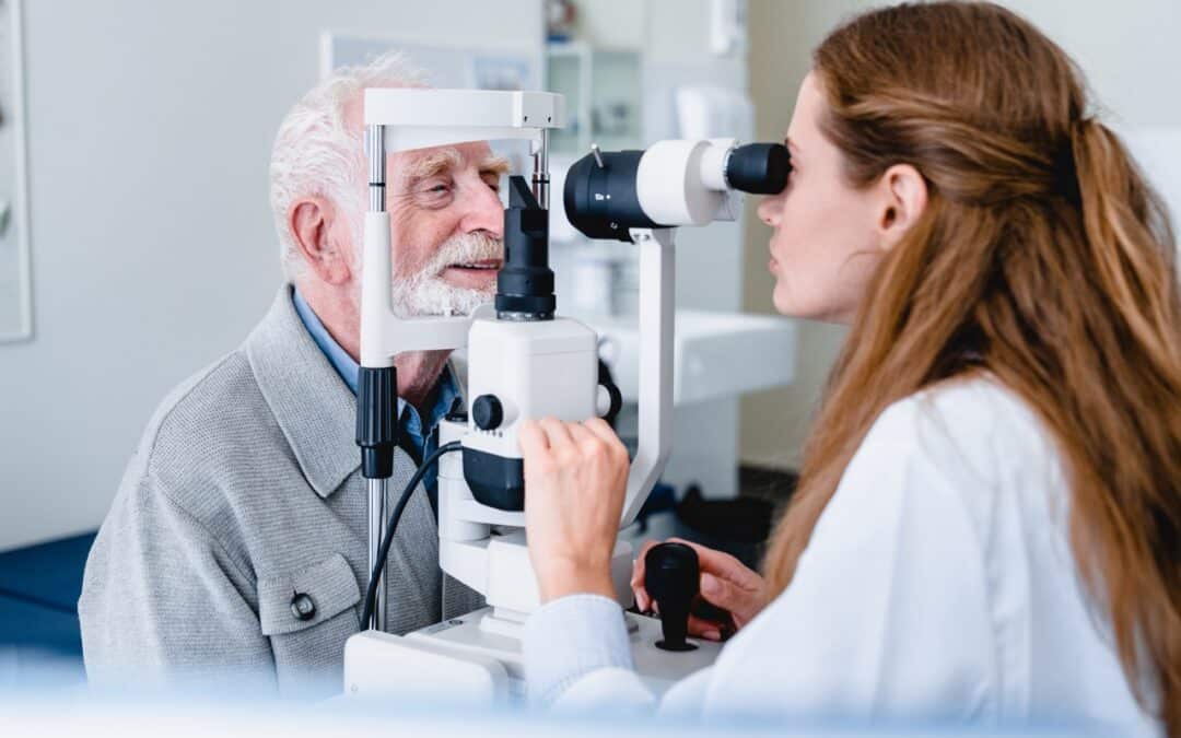 An elderly man getting his eyes checked by an ophthalmic doctor