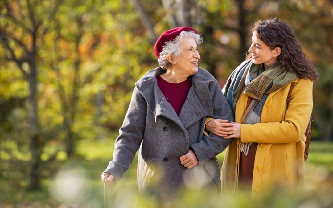 A woman talking to her elderly mom while out walking