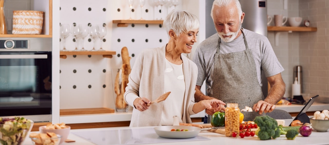 Elderly couple cooking a healthy meal together