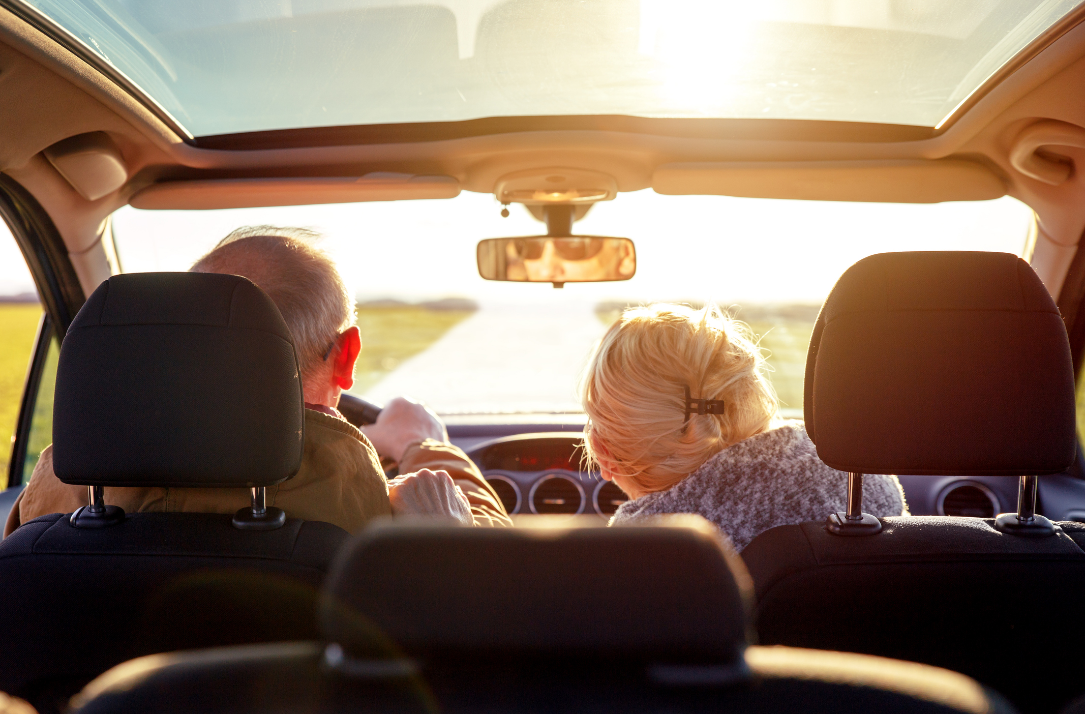 An elderly couple in a car